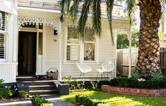 A White House with A Palm Tree and A Well-Maintained Lawn, Creating a Serene and Tropical Ambiance — Quantum Buyers Agent in Bowen Hills, QLD